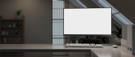 A modern office with a white-screen computer mockup and a keyboard on a table in a modern room. photo