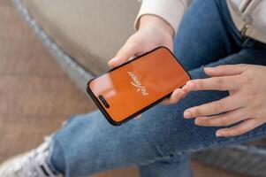 A close-up shot of a woman using the Payoneer application on her iPhone while sitting outdoor. photo