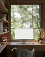 Modern vintage and cosy home office workspace with a white-screen computer mockup on a wooden table. photo