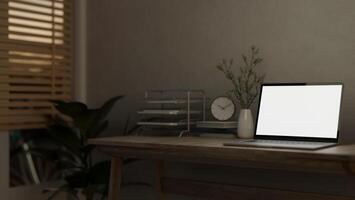 A laptop computer mockup and decor are placed on a hardwood desk in a minimally cozy home office. photo