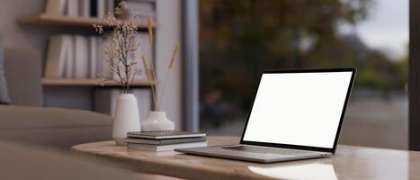 A close-up shot of a laptop computer on a coffee table in a contemporary and cozy living room. photo