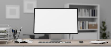 A white-screen computer mockup and office supplies on a wooden desk in a modern office. photo