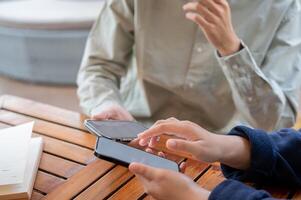 Two people sharing contact info or transferring files by bringing two smartphones close together. photo