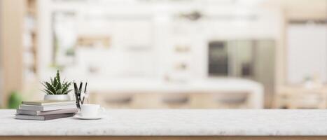 Books, a pencil stand, a coffee cup, a potted plant, and empty space on a tabletop in a kitchen. photo