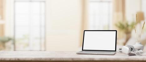 A marble desk with a laptop mockup set against the blurred background of a modern home office. photo