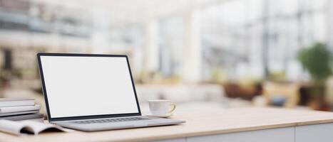 A laptop on a minimal wood table with a blurred background of a spacious luxurious living room. photo