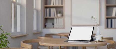 A digital tablet on a wooden table in a minimalist contemporary coffee shop or co-working space. photo