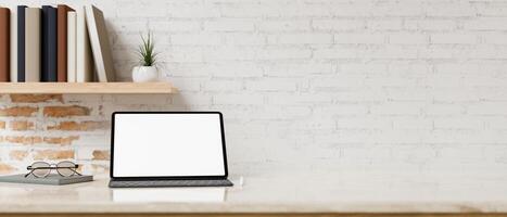 un pantalla blanca digital tableta Bosquejo en un mesa en contra el blanco rústico ladrillo pared. foto