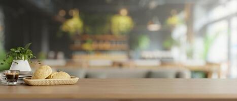 A wooden tabletop features a bread basket and a coffee cup in a modern restaurant or coffee shop. photo