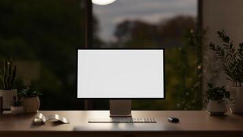 A modern dark office at night with a white-screen computer mockup and accessories on a wooden desk. photo