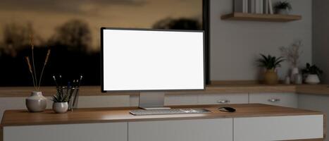 A computer mockup and decor on a wooden desk in a minimalist contemporary room in the evening. photo