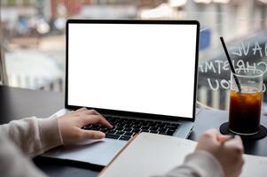 A close-up image of a college student studying online on her laptop computer at a coffee shop. photo