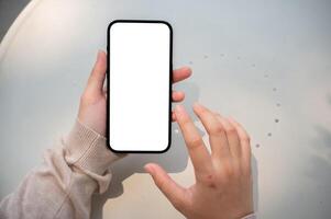 un de cerca imagen de un mujer se sienta al aire libre en un soleado día y usos su teléfono inteligente, mecanografía en pantalla. foto