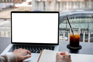 A close-up image of a college student studying online on her laptop computer at a coffee shop. photo