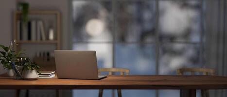 un cómodo hogar oficina espacio de trabajo con un ordenador portátil computadora y decoración en un de madera mesa. foto