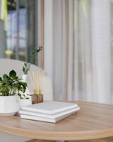 A round wooden table near in a contemporary room features books and decor plants on the table. photo