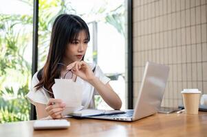 A female accountant is checking bills and receipts, working on business financial data on her laptop photo