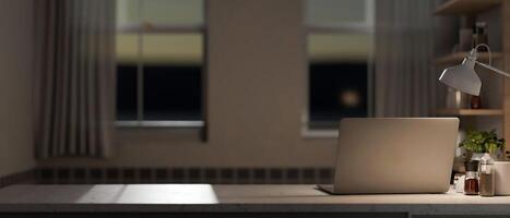 un hogar oficina espacio de trabajo con un ordenador portátil computadora en un mesa en el habitación en el noche. foto