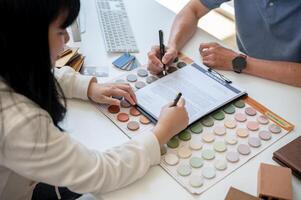 A female client signing a building insurance contract paper in front of the contractor in the office photo