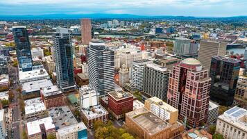 Downtown of Portland, Oregon, the USA with high-rise architecture. Twilight view of the city with mountain silhouettes at backdrop. photo