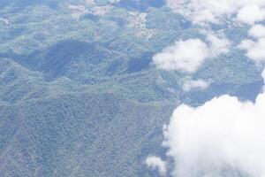 Aerial view of lands and clouds seen through airplane window photo