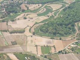 Aerial view of agricultural fields, river, mountains, and land have seen through the airplane window photo