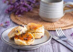 Close-up of traditional British scones placed on a plate with a teacup and flower blurred background. Space for text photo