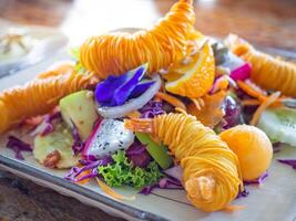 Fresco Fruta ensalada y camarones frito con espaguetis en un plato en un de madera mesa. vistoso con selectivo enfocar. parte superior vista. concepto de salud comidas foto