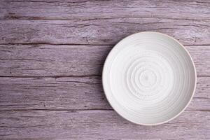 Top view of a plate on an old wooden table. Space for text photo