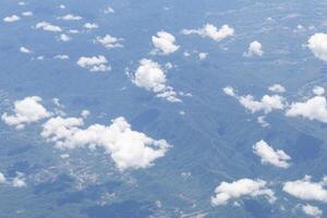 Aerial view of lands and clouds seen through the airplane window photo