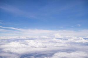 Aerial view of clouds and sky seen through the airplane window photo