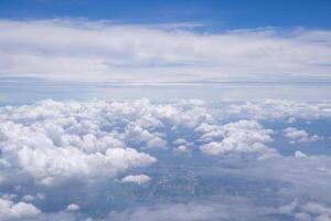 Aerial view of clouds and sky seen through the airplane window photo