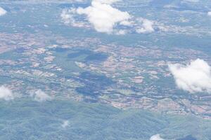 Aerial view of mountains, sky, and clouds are seen through the airplane Window photo