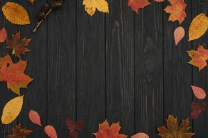 Background texture with old wooden table and yellow autumnal leaves. Autumn maple leaves on wooden background with copy space. Top view. photo