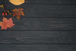 antecedentes textura con antiguo de madera mesa y amarillo otoñal hojas. otoño arce hojas en de madera antecedentes con Copiar espacio. parte superior vista. foto