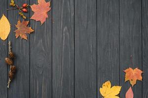 Background texture with old wooden table and yellow autumnal leaves. Autumn maple leaves on wooden background with copy space. Top view. photo