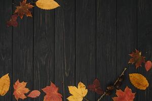 Background texture with old wooden table and yellow autumnal leaves. Autumn maple leaves on wooden background with copy space. Top view. photo