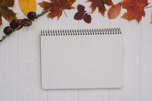 Background texture with old wooden table and yellow autumnal leaves. Autumn maple leaves on wooden background with copy space. Top view. photo