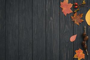 Background texture with old wooden table and yellow autumnal leaves. Autumn maple leaves on wooden background with copy space. Top view. photo