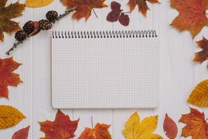 Background texture with old wooden table and yellow autumnal leaves. Autumn maple leaves on wooden background with copy space. Top view. photo