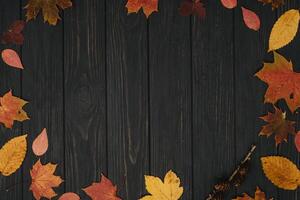 Background texture with old wooden table and yellow autumnal leaves. Autumn maple leaves on wooden background with copy space. Top view. photo