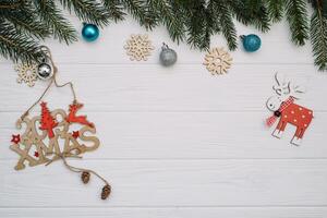 Christmas fir tree with decoration and glitters on wooden background. Christmas background on the white wooden desk photo