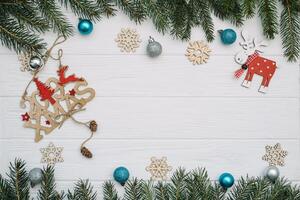 Christmas fir tree with decoration and glitters on wooden background. Christmas background on the white wooden desk. photo