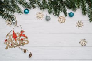 Christmas fir tree with decoration and glitters on wooden background. Christmas background on the white wooden desk. photo