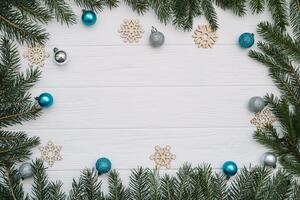 Christmas fir tree with decoration and glitters on wooden background. Christmas background on the white wooden desk photo