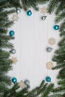 Christmas fir tree with decoration and glitters on wooden background. Christmas background on the white wooden desk photo