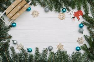 Christmas fir tree with decoration and glitters on wooden background. Christmas background on the white wooden desk photo