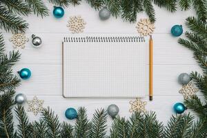 Christmas fir tree with decoration and glitters on wooden background. Christmas background on the white wooden desk photo