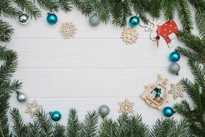 Christmas fir tree with decoration and glitters on wooden background. Christmas background on the white wooden desk photo