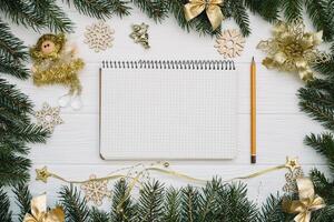 Christmas fir tree with decoration and glitters on wooden background. Christmas background on the white wooden desk photo